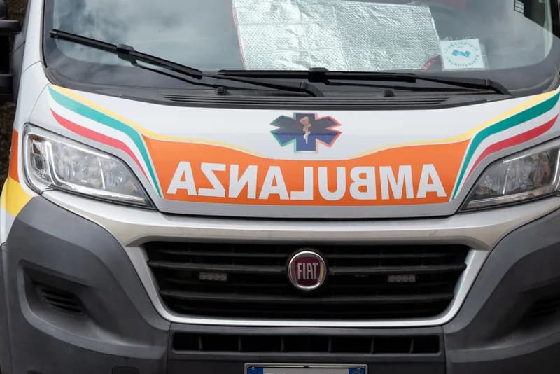 An Italian Red Cross ambulance parked outside a hospital entrance in the Forlì area